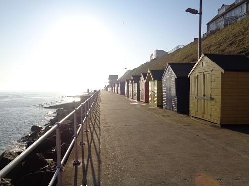 Heading into the morning sun past some beach huts in Sheringham