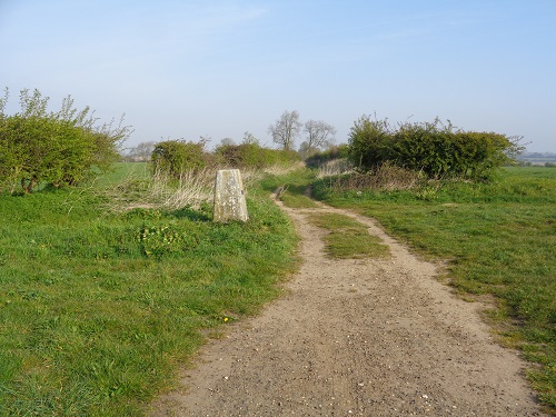 A Trig Point marks the end of a long road section and onto tracks